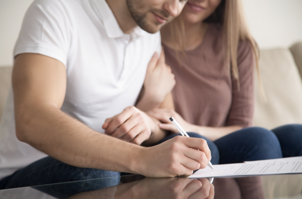 Couple reviewing and signing trust administration documents at home in California.
